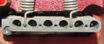 The ball-ends of the strings installed in slots of a synchronized vibrato system in the electric guitar