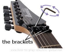 Loosen the string locking bracket on the Ibanez guitar with a string locking mechanism while restringing