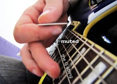 The image illustrates muting the nearby string by putting the side of the picking hand on it